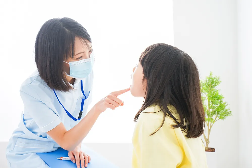 こどもの歯を確認する歯科衛生士